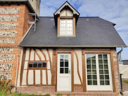 a house with a window and a white door at La Sellerie et Le Relais des Hortensias in Graincourt