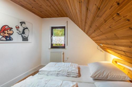 ein Schlafzimmer mit einem Bett und einer Holzdecke in der Unterkunft Landhaus Sophie in Frielendorf