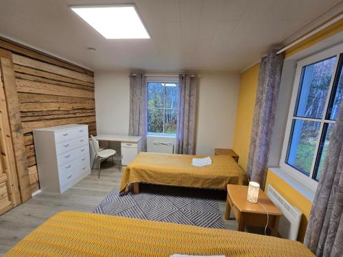 a bedroom with two beds and a desk and window at Grete's House in Eurajoki