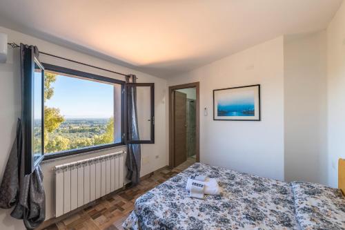 a bedroom with a bed and a large window at Affittacamere Gutturu e Forru in Villacidro