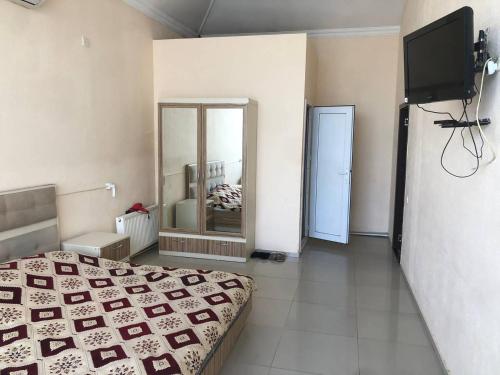 a bedroom with a bed and a mirror and a television at İzmir can hotel in Baku