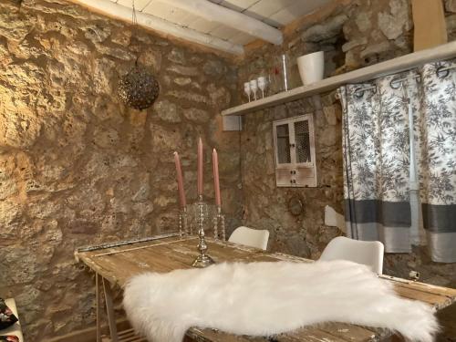 a dining room with a table and a stone wall at Terre de Caliso in Carnoules