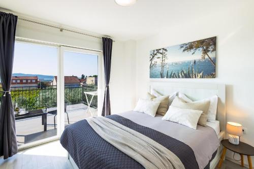 a bedroom with a large bed and a balcony at Villa Fidelissima in Kaštela