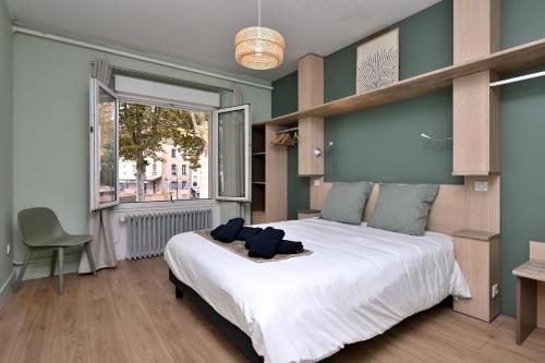 a bedroom with a large white bed and a window at Villa Milady in Salies-du-Salat