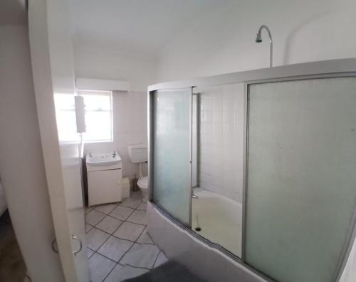 a bathroom with a glass shower and a toilet at Pik & Pikkie Self catering apartments in Lambertʼs Bay