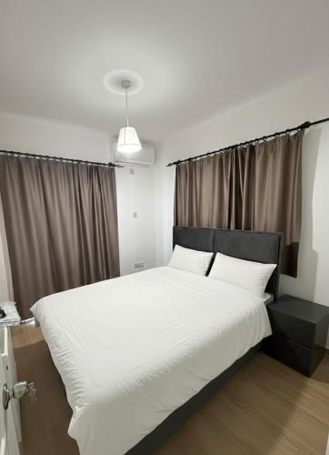 ein Schlafzimmer mit einem großen Bett mit weißen Laken und Kissen in der Unterkunft Villa Keskin - Girne in Ayios Ioannis