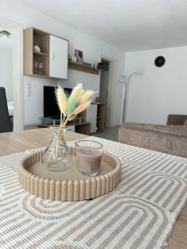 a table with a vase with feathers and a candle at Schwarzwald - Modern mit Terrasse in Schramberg