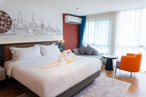 a hotel room with a bed with a stuffed animal on it at L-Seven Hotel in Bangkok