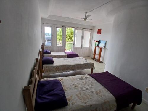 a group of four beds in a room at Pousada recanto das ondas in Macaé