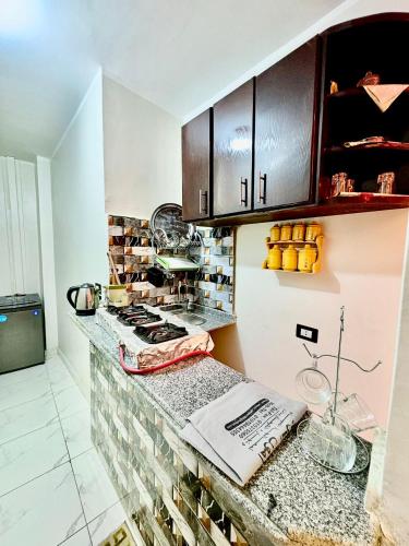 a kitchen with a counter with a stove and cabinets at Al FAHAD private apartments for rent in Luxor