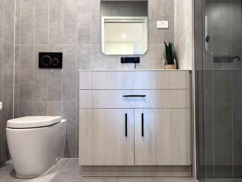 a bathroom with a toilet and a mirror at Full of Fun shopping 1BR stay at Clayton in Clayton North