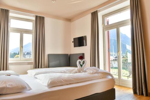 una camera da letto con due letti e una finestra di Hotel Savoia a Dobbiaco