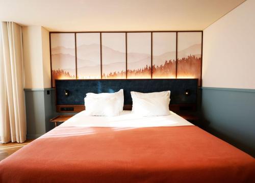 a bedroom with a large bed with a red blanket at Montebelo Viseu Congress Hotel & Spa in Viseu