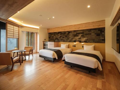a bedroom with two beds and a table and chairs at Hakone Hibarino in Hakone