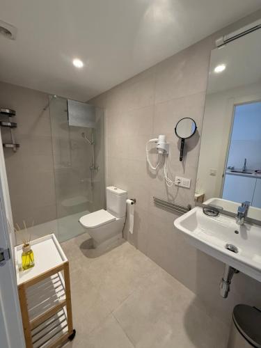 a bathroom with a toilet and a shower and a sink at K&A Apartments in Valencia