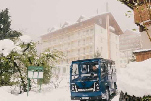 a man driving a golf cart in the snow at Grand Hotel Belvedere, a Beaumier Hotel in Wengen