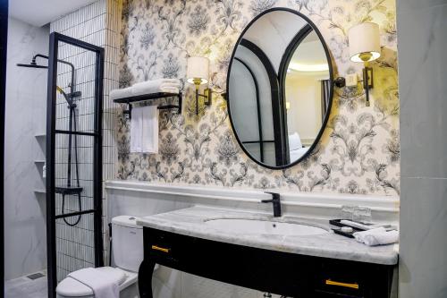 にあるSwiss-Belexpress Paluの洗面台と壁に鏡が付いたバスルーム