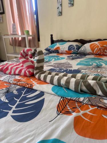 a bed with a colorful blanket on top of it at Subangan Veranda1, Burgos Central location in Burgos