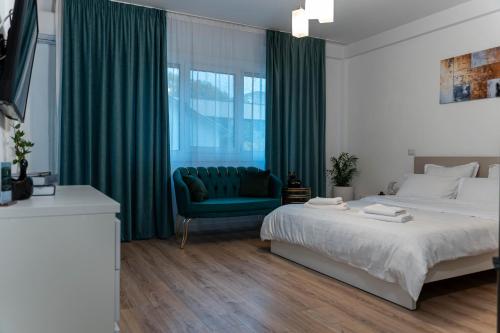 a bedroom with a bed and a green couch at Vanguard Suite De Lux in Craiova