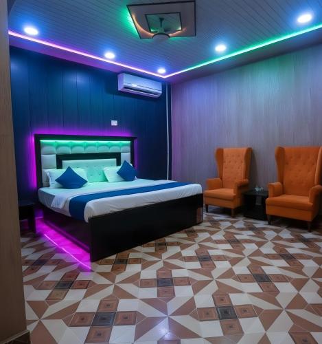 a bedroom with a bed and two chairs in a room at TRIP MY BUDDY Hotels in Varanasi