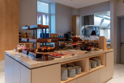 a buffet line with dishes and food on display at Meliá São João da Madeira in São João da Madeira