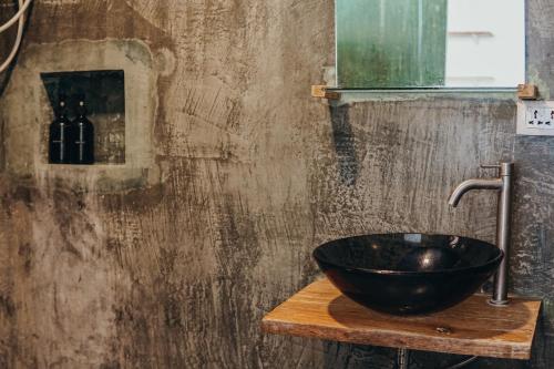 La salle de bains est pourvue d'un lavabo noir sur un comptoir en bois. dans l'établissement Central Loft 2-3 mins away from Surf Spots, à General Luna