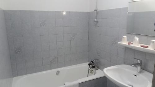 une salle de bain avec un lavabo, une baignoire et des toilettes dans l'établissement Hôtel Le Mont Jorat, à Abondance