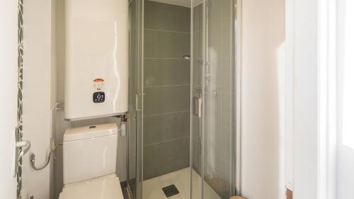 Un baño con inodoro y ducha de cristal. en BonAppart 13 - Charme Napoléonien & Confort, en Troyes