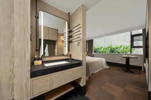 ein Badezimmer mit Waschbecken und Spiegel in der Unterkunft SDADSBESÖK Dragon Pearl Hotel (Yibin Guanying Ancient Street Hejiangmen Plaza Branch) in Nanguang