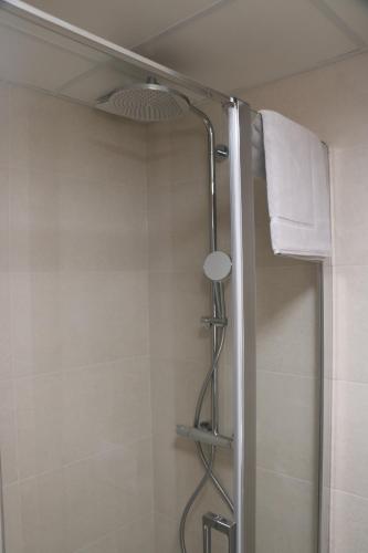 La salle de bains est pourvue d'une douche avec rideau de douche. dans l'établissement Abalys Hotel, à Brest