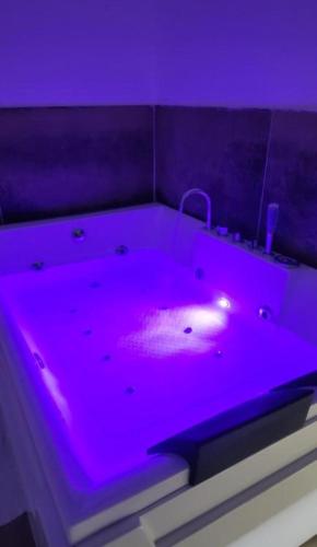 a bath tub with purple lighting in a room at Idromasage room in Catania