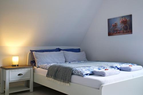 een slaapkamer met een bed en een nachtkastje met een lamp bij Ruhe am Walde in Meschede