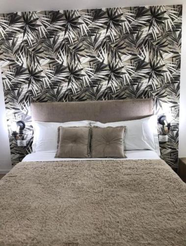 a bedroom with a large bed with a black and white wallpaper at Idromasage room in Catania