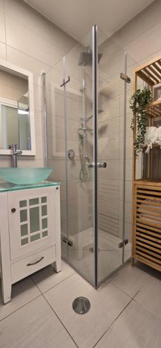 a bathroom with a glass shower with a sink at GoldSea - Boutique Seafront Studio in Nahariyya
