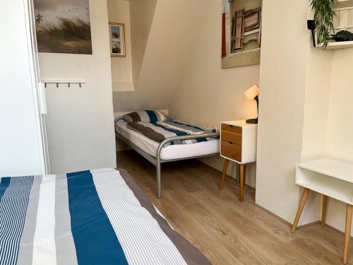 una habitación pequeña con una cama y un escritorio en Familiehuis Castor 300 m van het strand, en Noordwijk aan Zee
