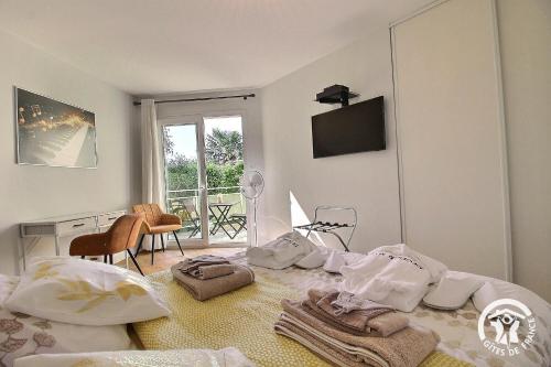 a white room with a bed with towels on it at La rose des vents in La Chèze