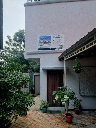 a building with a sign on the side of it at The Happy Homestay in Nāmkom
