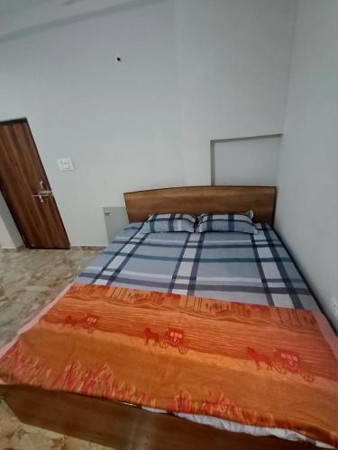 a bedroom with a bed with a wooden head board at The Happy Homestay in Nāmkom