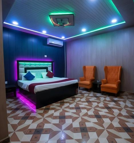 a bedroom with a bed and two chairs in a room at TRIP MY BUDDY Hotels in Varanasi