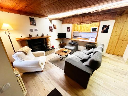 een woonkamer met twee banken en een open haard bij SNÖ Casa Pucurull in Salardú
