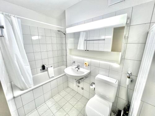 un bagno bianco con lavandino e WC di WA - Penthouse 6 Pax City Apartment Zürich a Zurigo