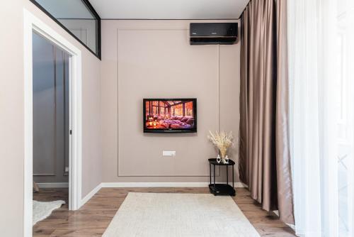 a living room with a tv on a wall at Квартира в ЖК бизнес класса in Almaty