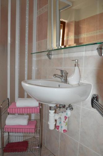 a bathroom with a sink and a mirror and towels at Apartmány U Vaců in Železná Ruda