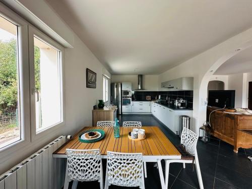 Un comedor con mesa y sillas y una cocina. en Villa du sud avec piscine et jardin, en Saint-Christol-lès-Alès