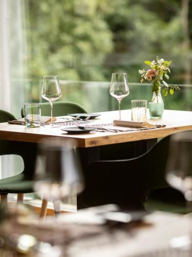 a table with wine glasses and a vase of flowers at Ladurner in Lagundo