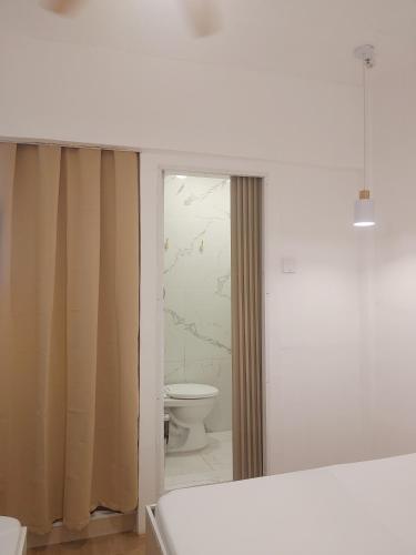 a white bathroom with a toilet and a window at Pierside Inn in Cebu City