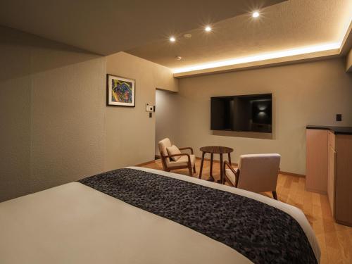 a hotel room with a bed and a flat screen tv at Hakone Hibarino hot spring hotel in Hakone
