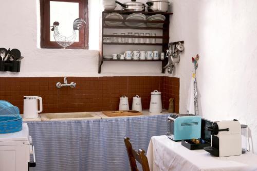 a kitchen with a counter with a sink and a table at Koutsounari Traditional Cottages in Koutsounari