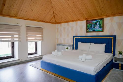 a bedroom with a blue bed in a room with windows at Qusar Boutique in Qusar