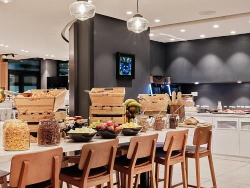 Una mesa larga con cuencos de comida encima en una cocina. en Crowne Plaza - Marseille Le Dôme, en Marsella